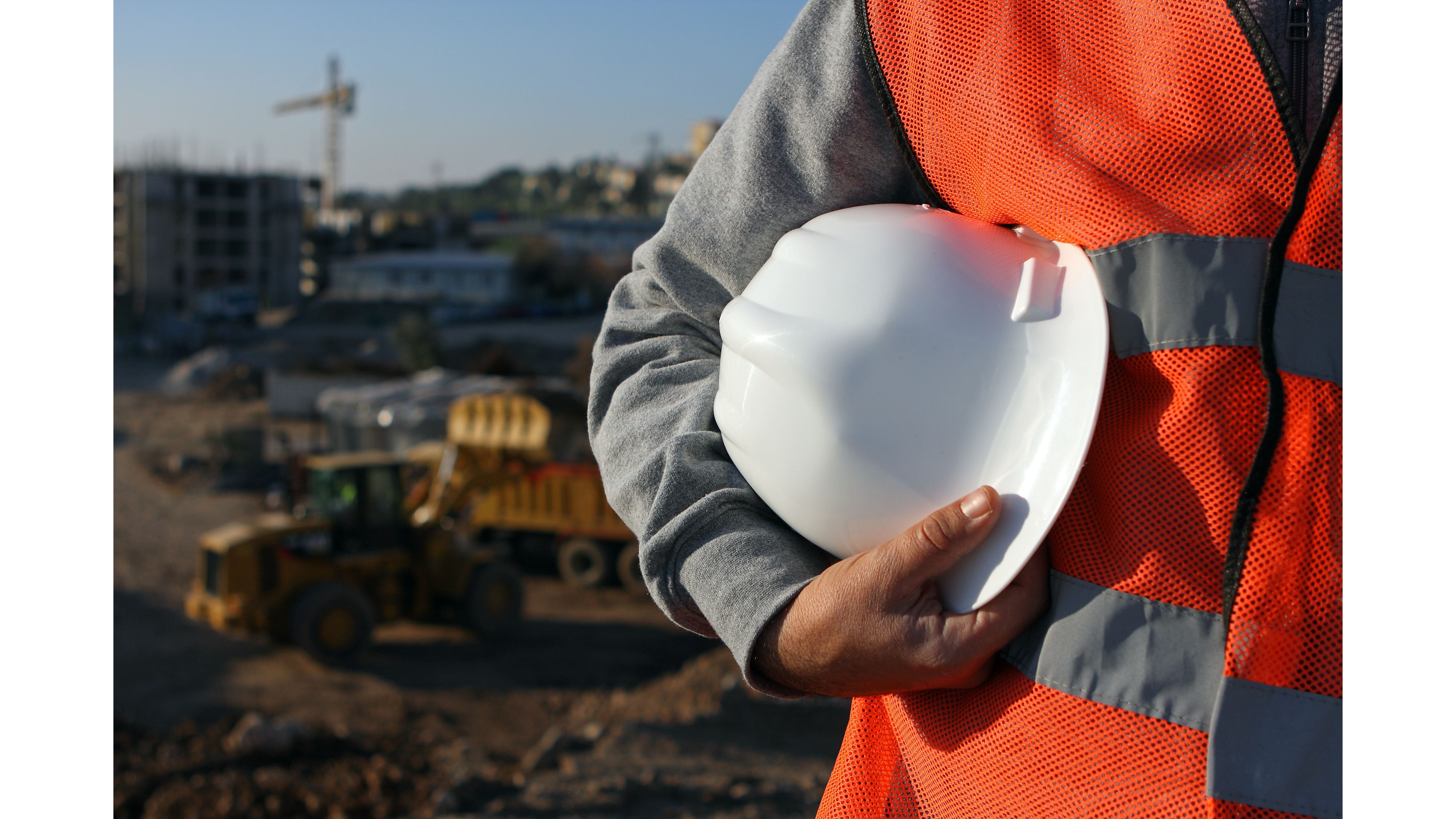 Profissional da construção civil segurando um capacete de segurança